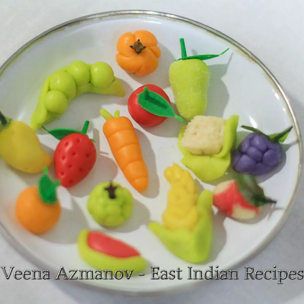 Marzipan fruits in a white plate.