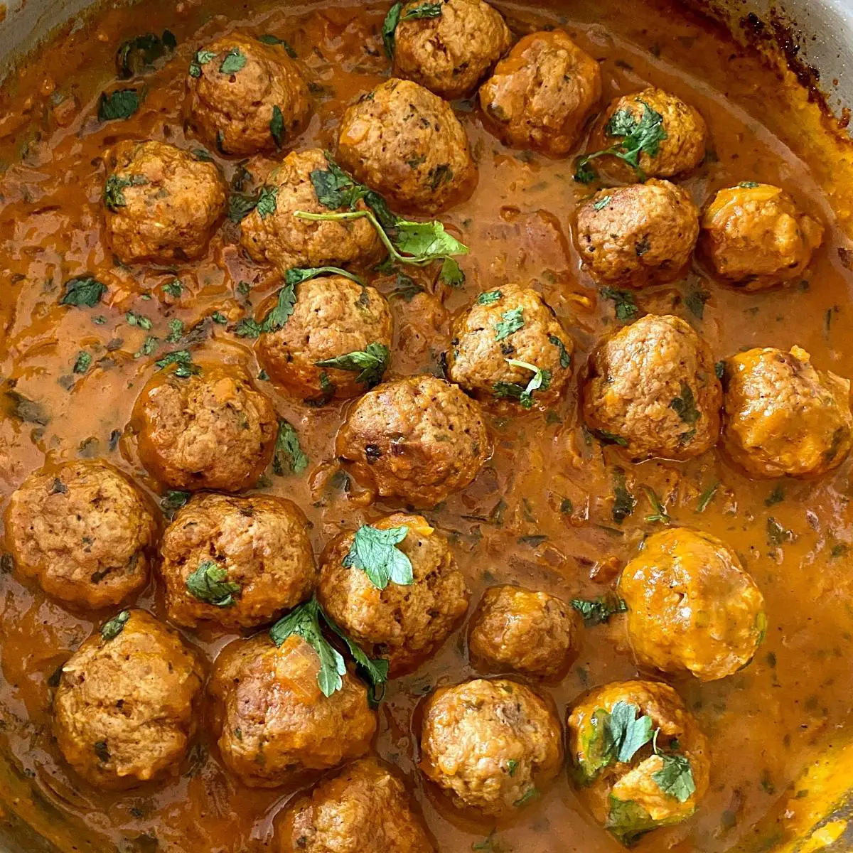 A skillet with meatballs curry.