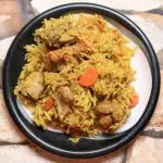 A plate with chicken and rice pulao.