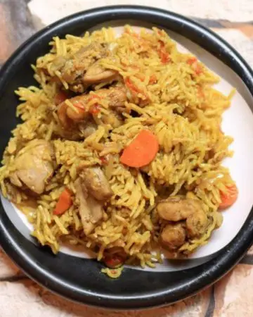 A plate with chicken and rice pulao.
