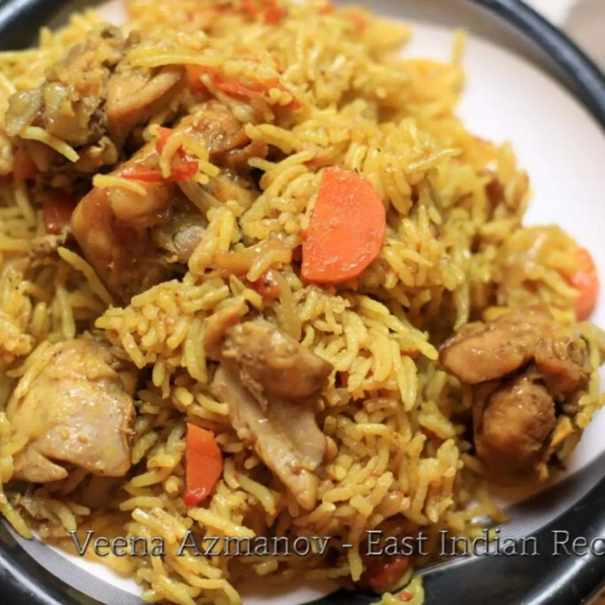 Pulao with carrots and chicken on a plate.