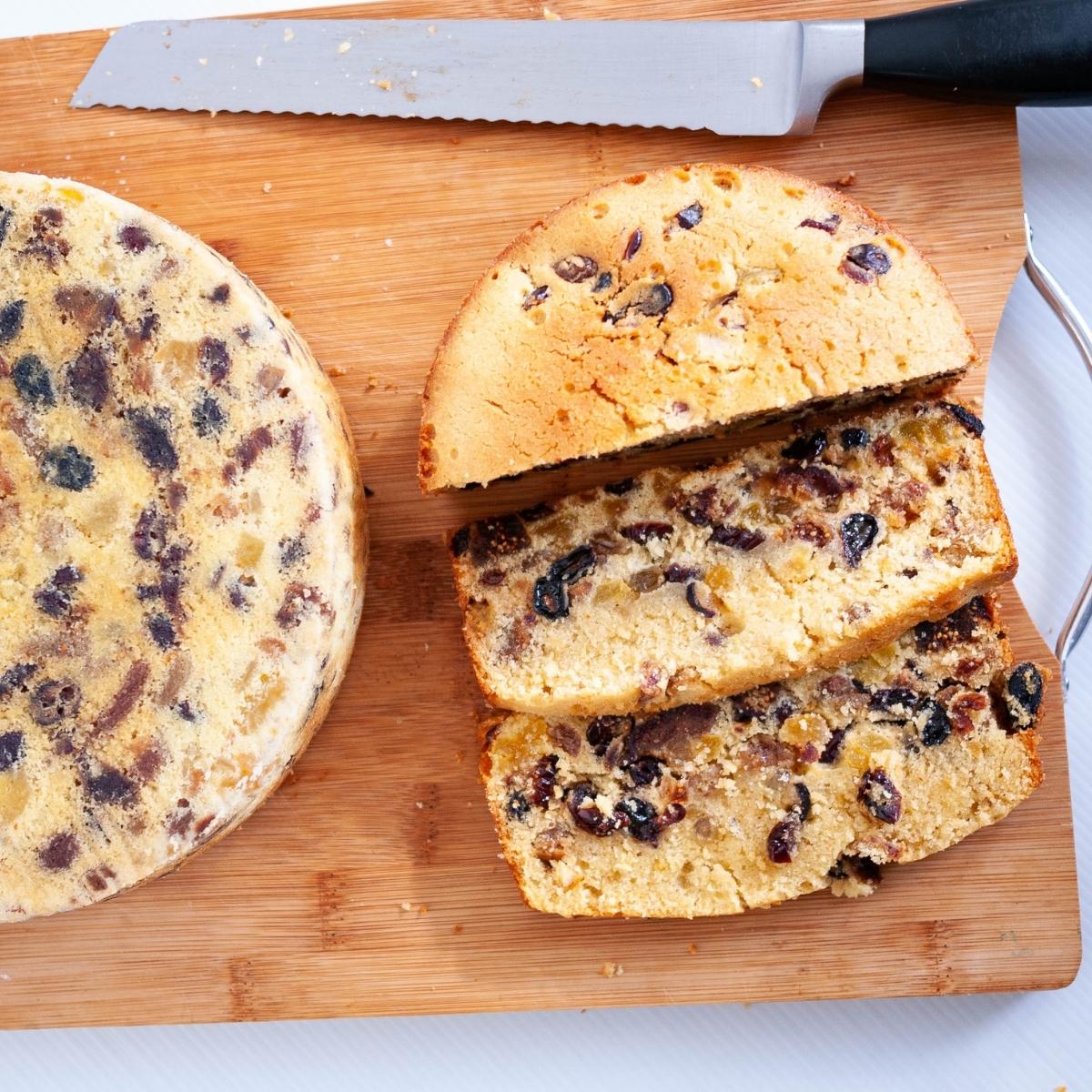 Sliced cake with dried fruits on a wooden board.