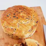 A baked and cooled cake fruitcake on a wooden board.