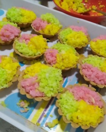 A tray with colored coconut tarts.