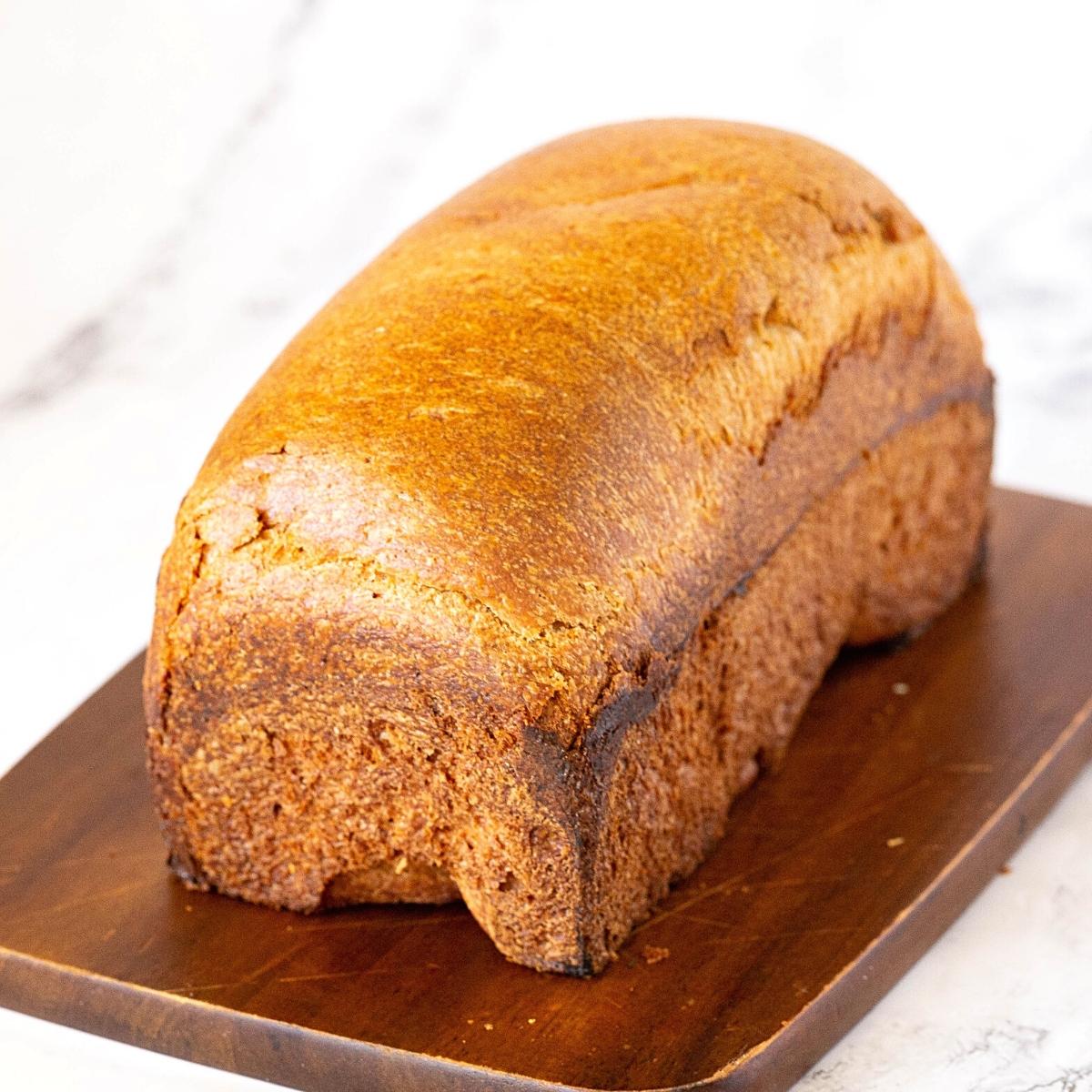 A baked loaf on a wooden board.