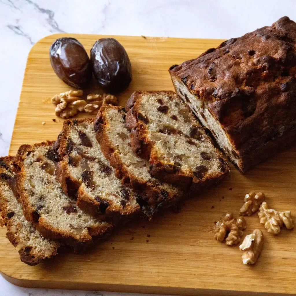 A wooden board with a loaf cake.