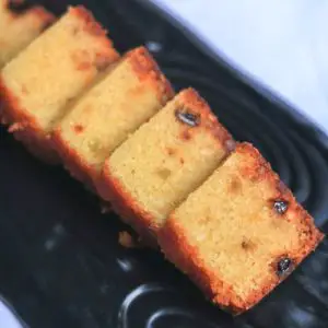 A black plate with plum cake slices.