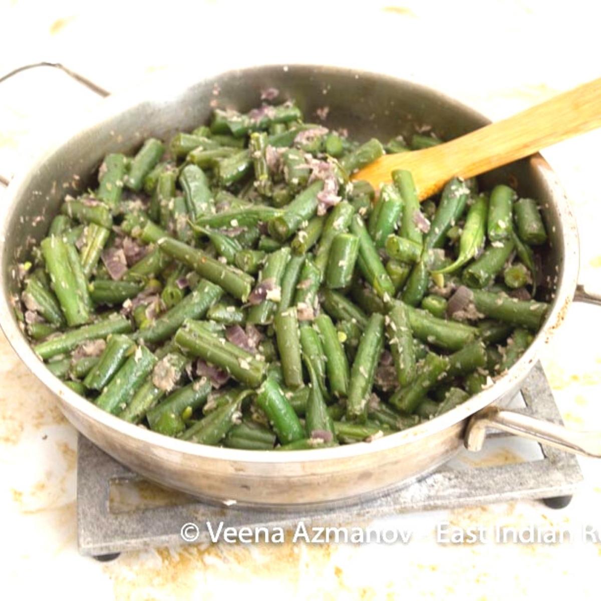 French beans foogath in a saute pan.