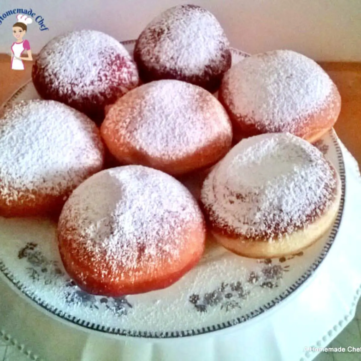 A plate with doughnuts and powdered sugar.