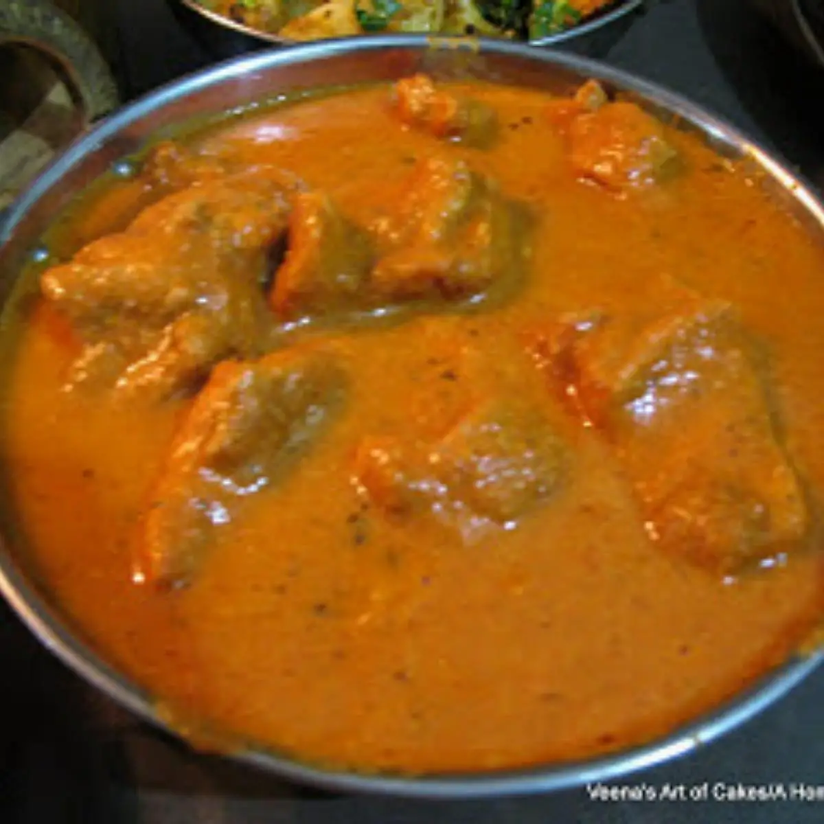A skillet with butter chicken.