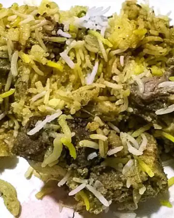 A plate with biryani recipe with mutton.