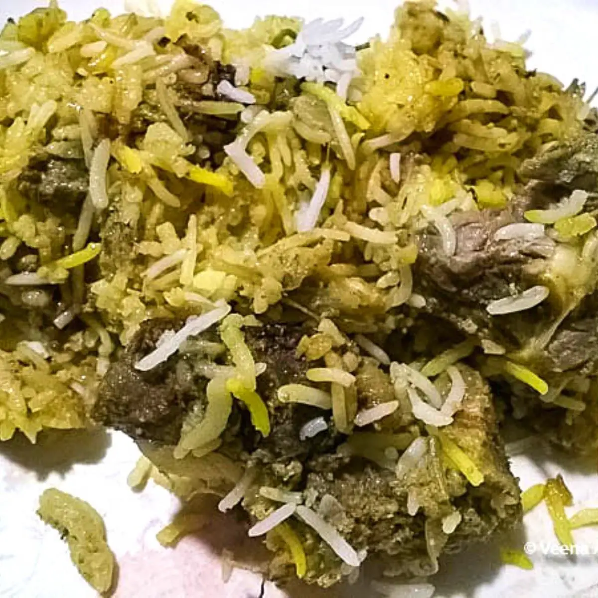 A plate with biryani recipe with mutton.
