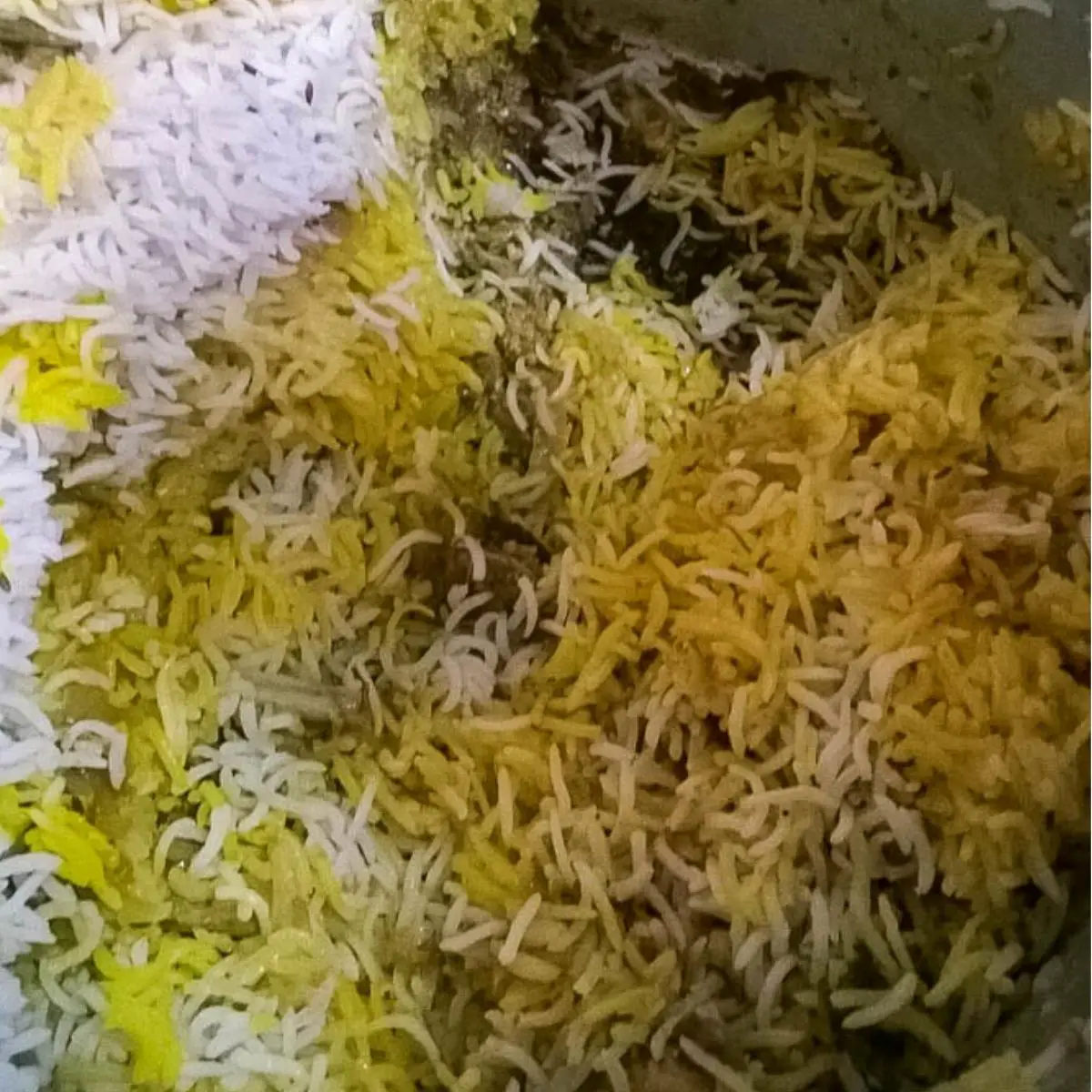 A pot of biryani cooking with mutton.