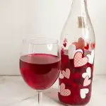 A wine glass an bottle with beetroot wine.