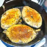 A skillet with pan fried fish.