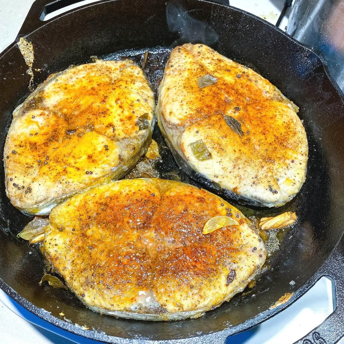 A skillet with pan fried fish. 