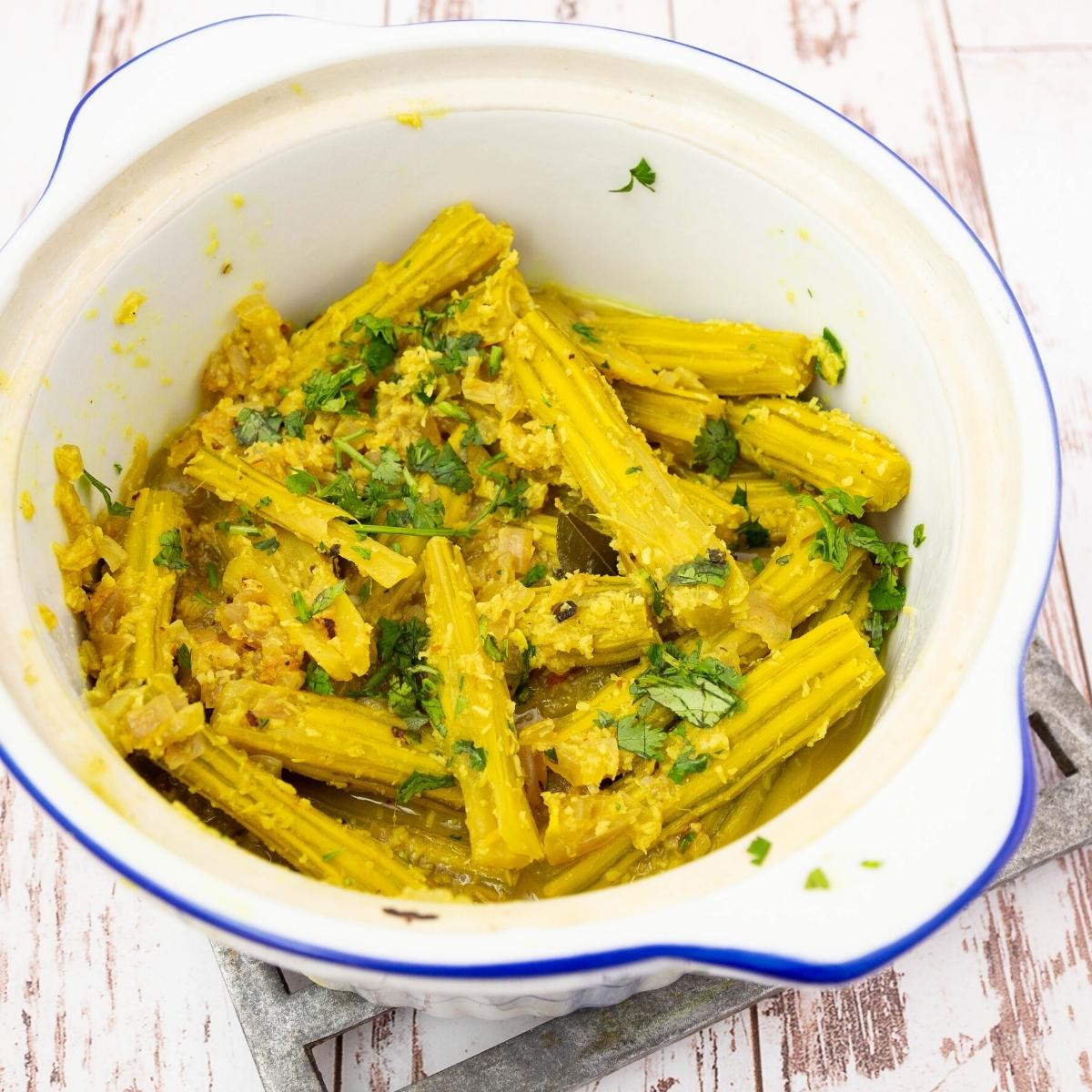 A serving dish with drumsstick bhaji.