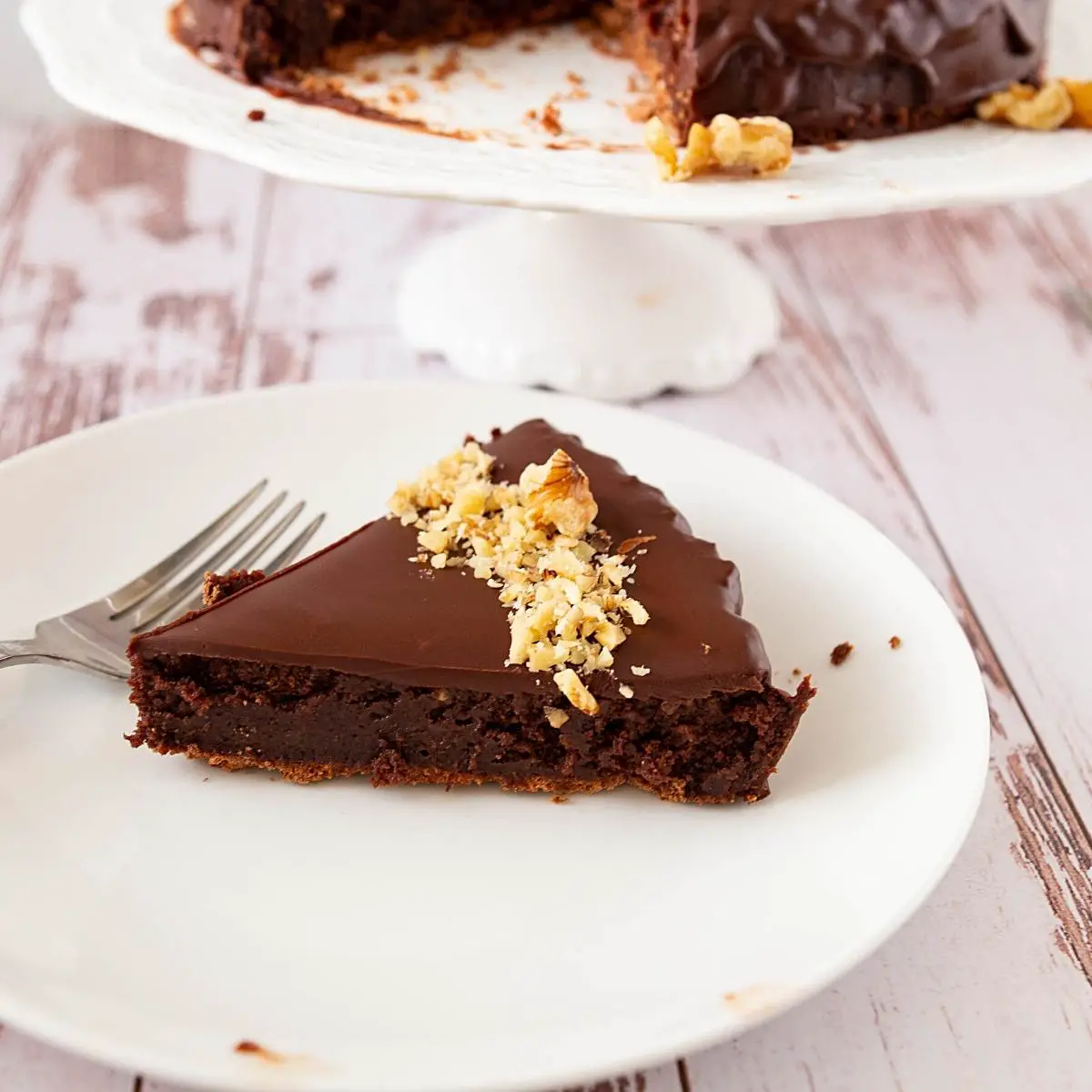 A slice of chocolate cake with walnuts.