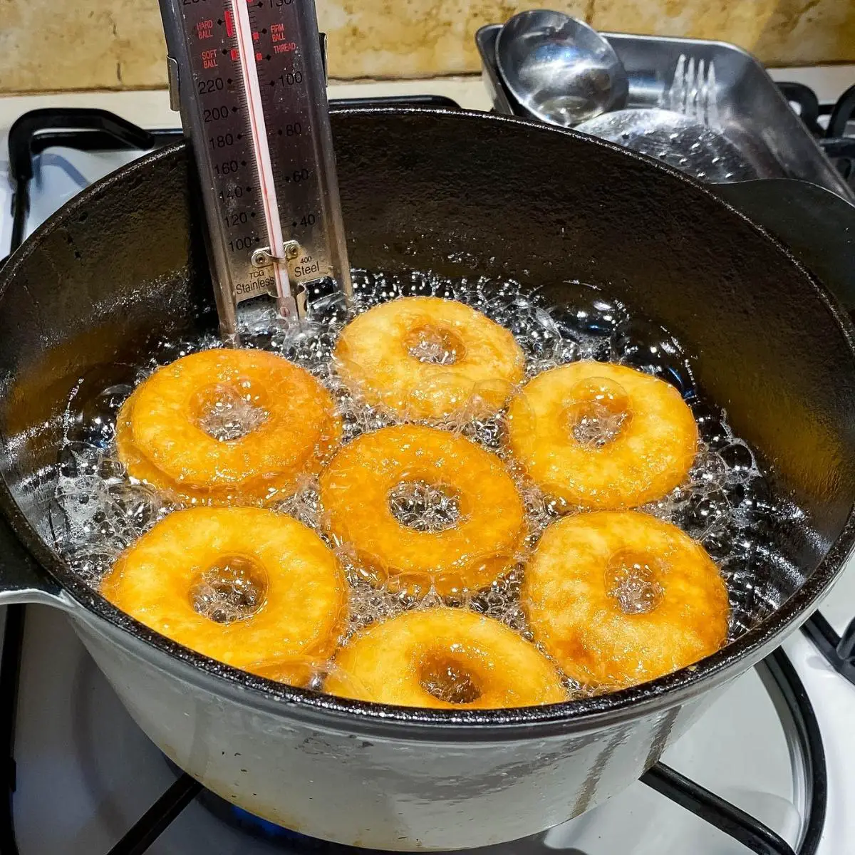 A cast Iron pot deep frying donuts.