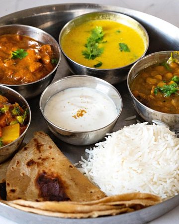A Indian thali with rice, chapati and vegetarian dishes.