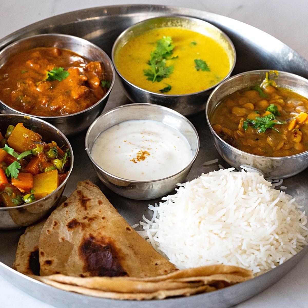 A Indian thali with rice, chapati and vegetarian dishes. 