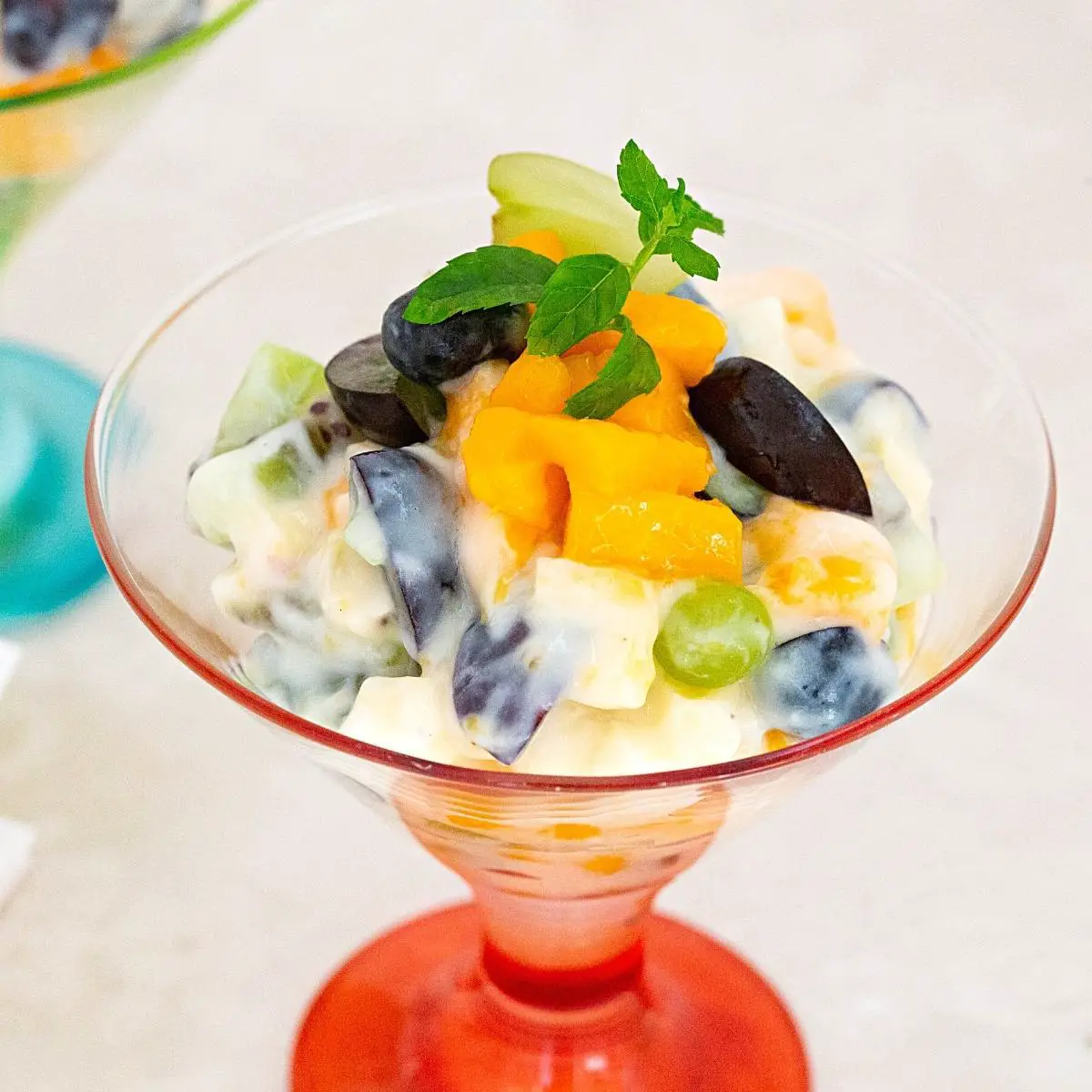 A cup of fruit salad with custard.