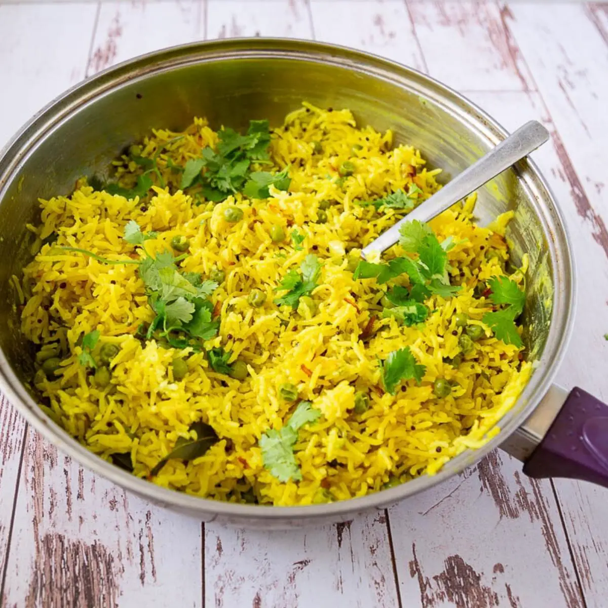 Yellow rice with coconut and turmeric in a skillet.