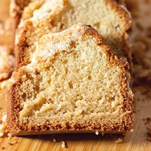 Sliced coconut cake in loaf pan.