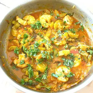A saute pan with pumpkin curry with prawns.