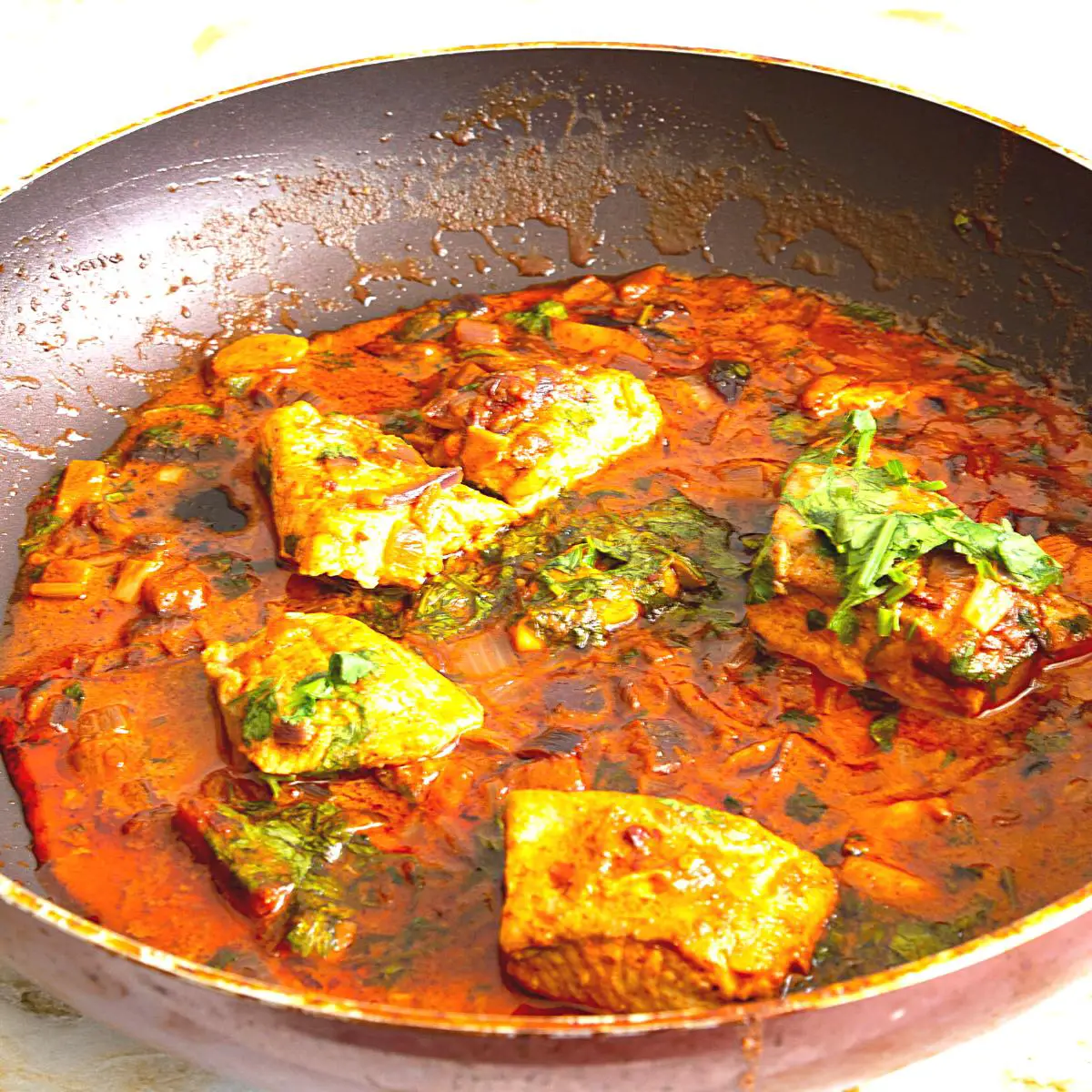 A skillet with fish curry.