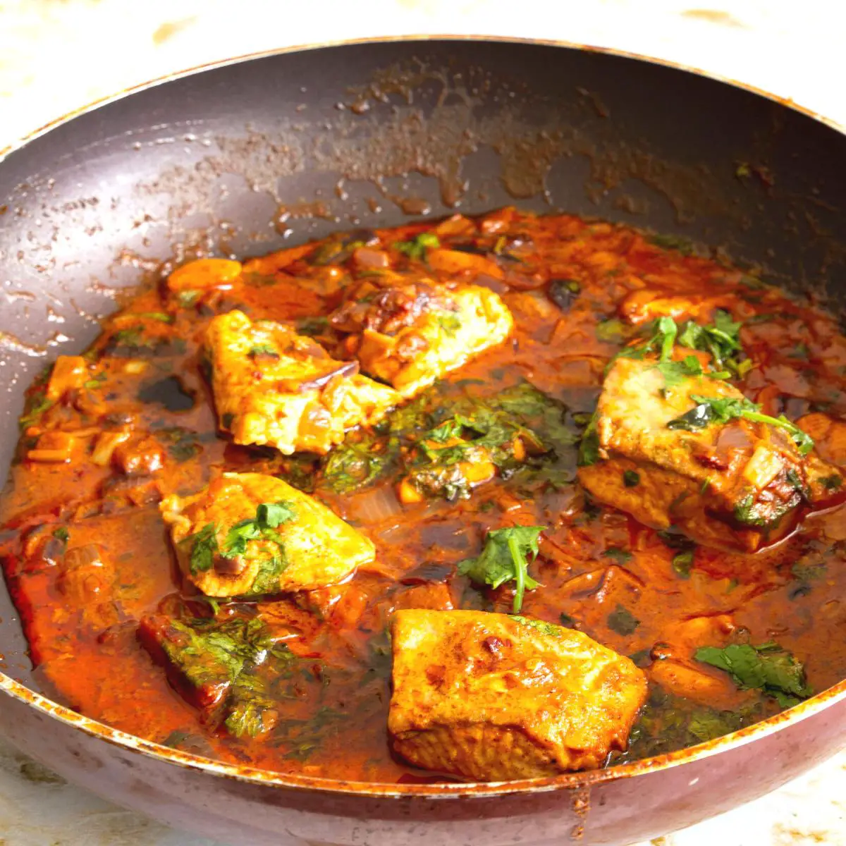 A skillet with curry fish.